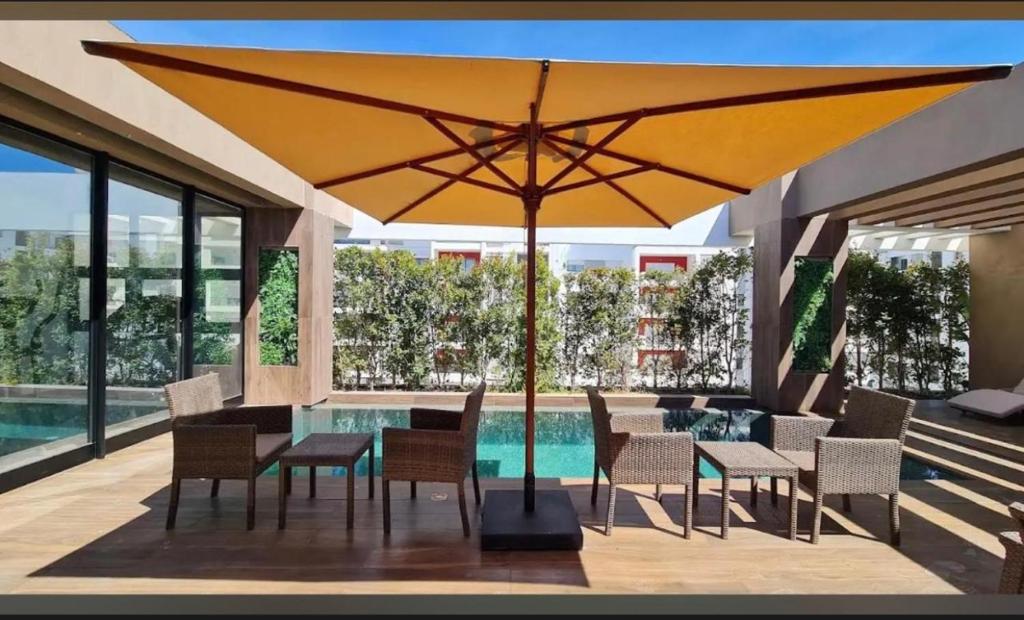 a large yellow umbrella over a table and chairs at Luxury apartment in Sidi Daoud