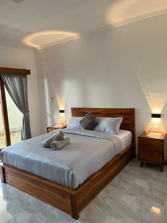 a bedroom with a large bed with two lamps at Rumah Harmoni in Ungasan