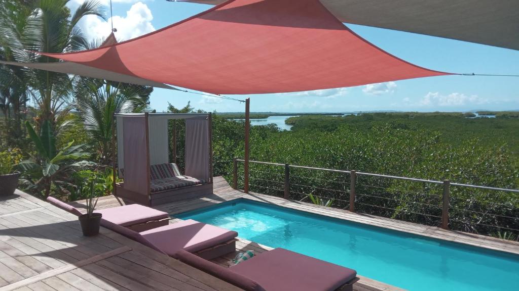 博卡斯德尔托罗维拉食宿度假村的一个带遮阳伞和躺椅的游泳池