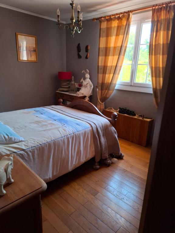 a bedroom with a bed and a desk and a window at Chez Fanfan in Cauville