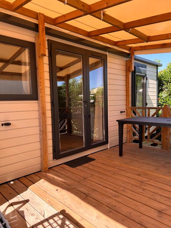 a screened porch with sliding glass doors on a house at le plein de bonheur in Fréjus
