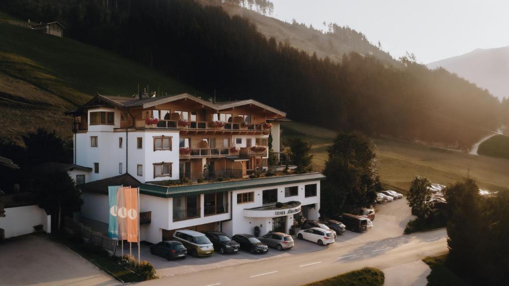 a large building with cars parked in a parking lot at Hotel Jörglerhof in Hainzenberg