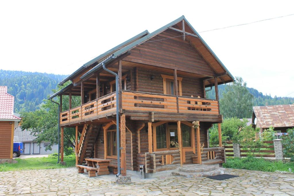 uma grande casa de madeira com um telhado de gambrel em Cottage u Yaremy Mykulychyn em Mykulychyn