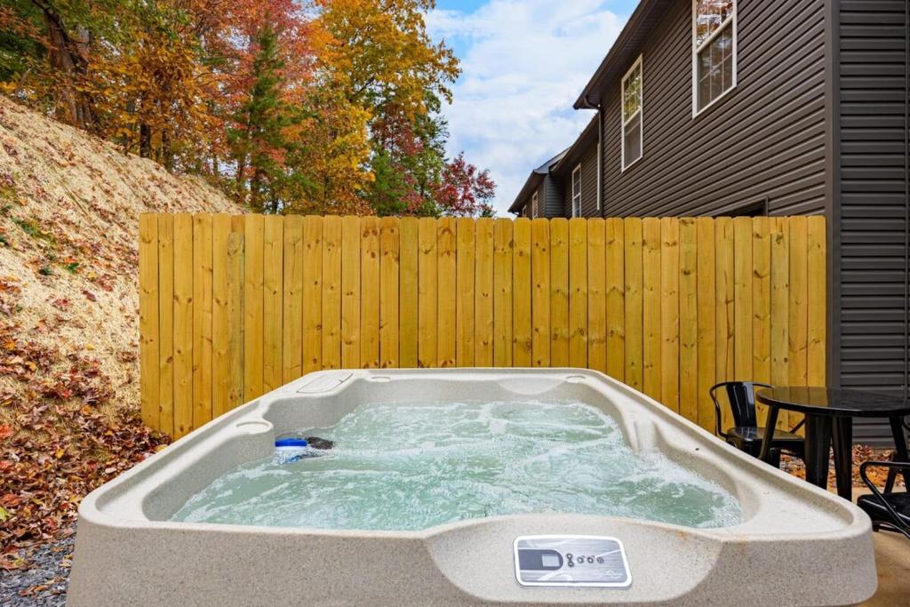 a hot tub in a backyard with a wooden fence at Peaceful Escape 2BR Retreat w Private Hot Tub in Sevierville