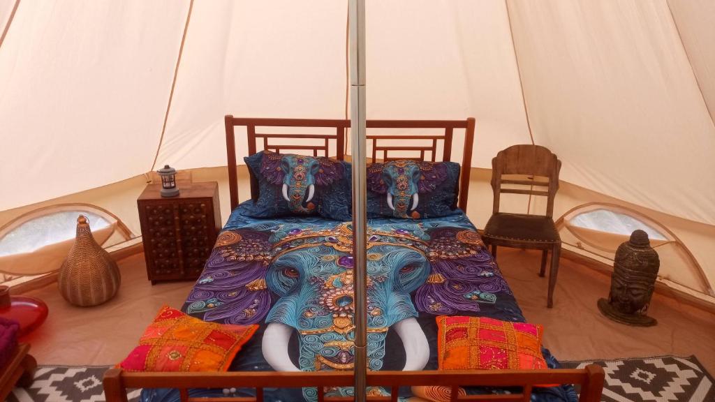 a bedroom with a bed in a tent at tente india in Le Pener