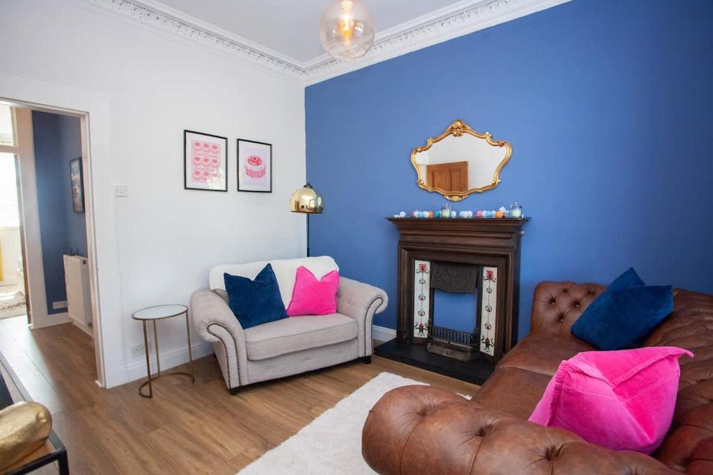 a living room with a couch and a chair and a mirror at 1 Bed Cosy Loch Lomond base in Bonhill