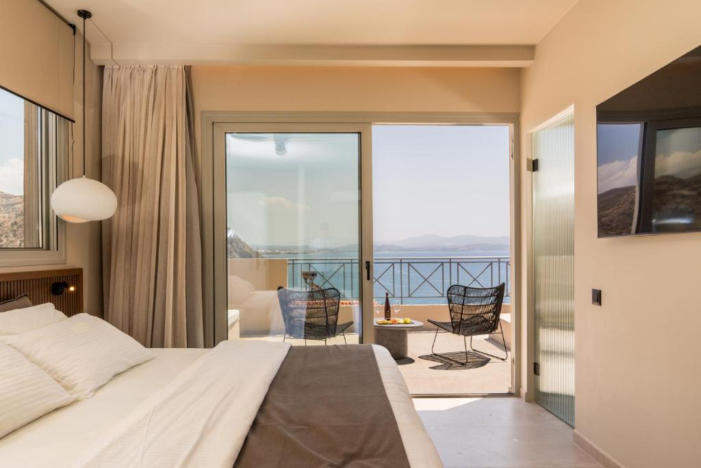 a bedroom with a bed and a balcony with a view at Astoria Hotel in Agia Galini