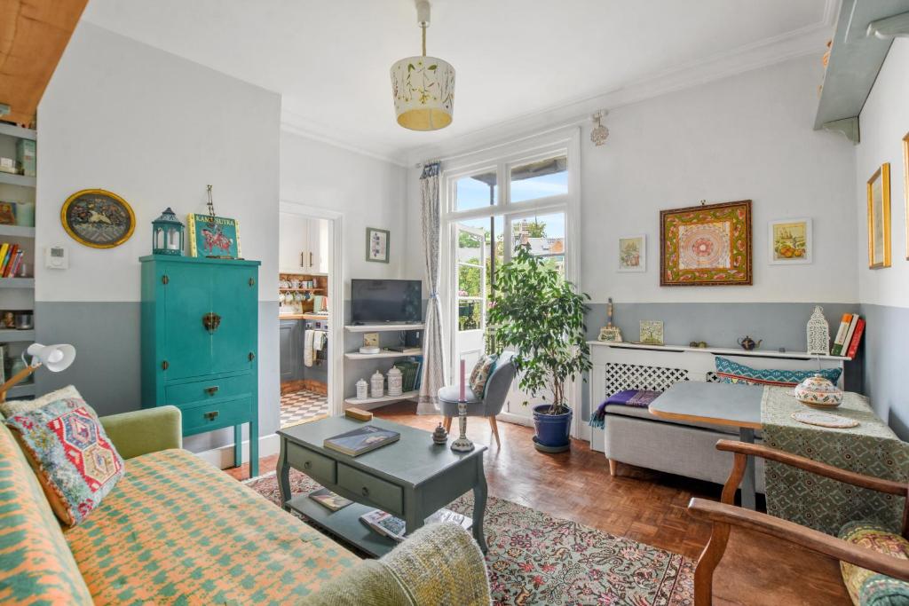a living room with a couch and a table at Charming London with balcony in London