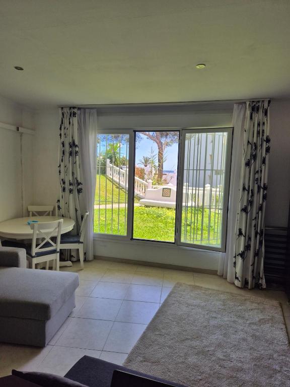 a living room with a couch and a large window at Apartment beachside in Calahonda in Cabopino