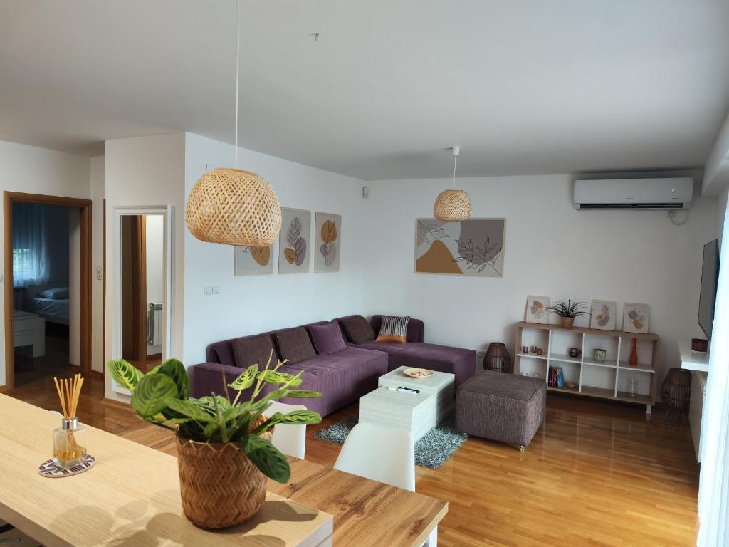 a living room with a purple couch and a table at FinePlace in Skopje