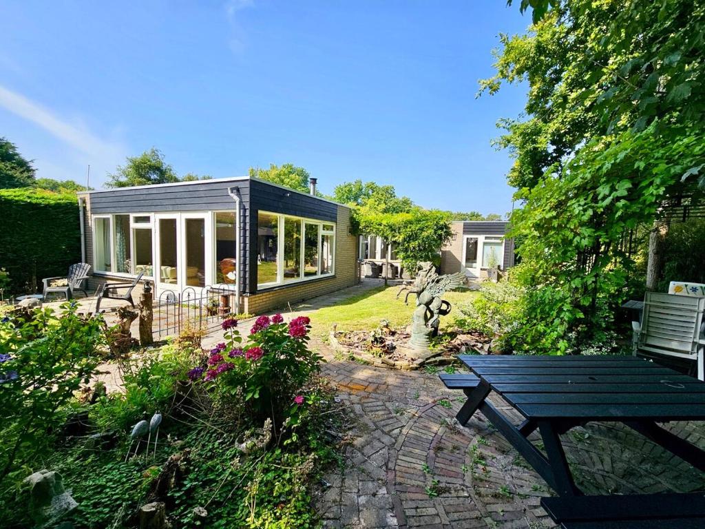 a garden with a bench and a house at Duinland 142 in Sint Maartensvlotbrug