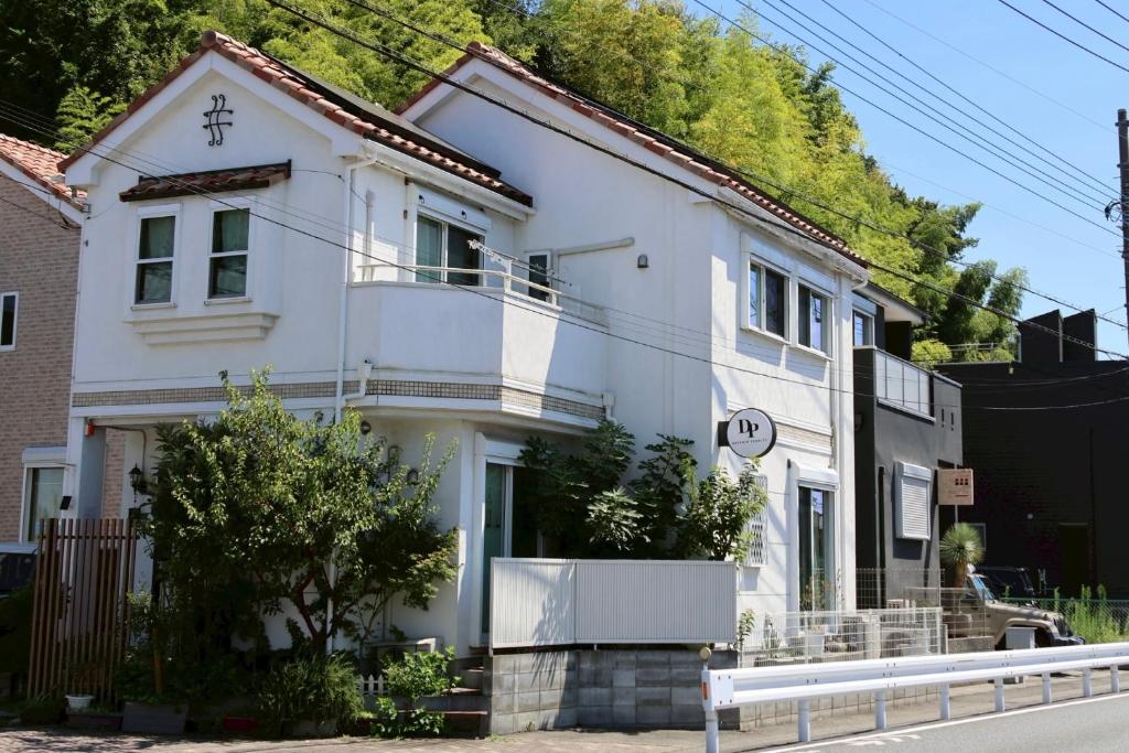 una casa blanca al costado de una calle en ｄｐ小山町, en Machida