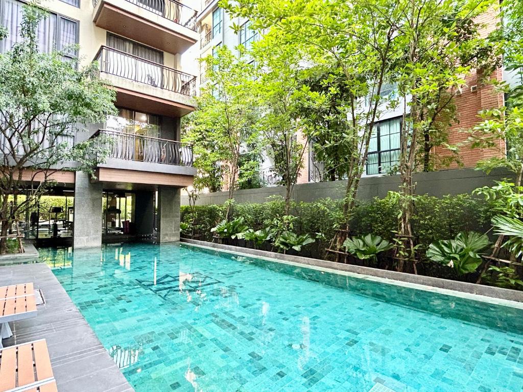 una piscina frente a un edificio en Klass Langsuan Condo, en Bangkok