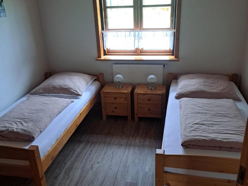 two beds in a small room with a window at Ferienhof Schlottmann in Achtrup