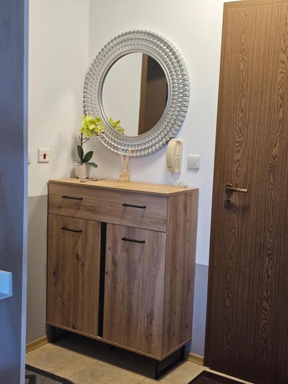 a mirror on top of a wooden dresser in a bathroom at Прекрасные апартаменты с видом на море в центре in Byala