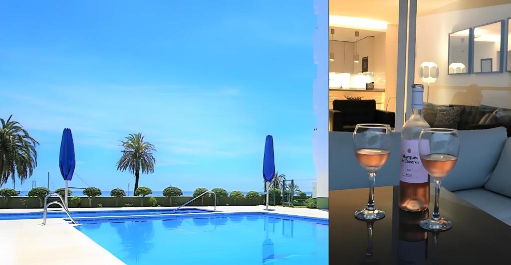 zwei Gläser Wein neben einem Pool in der Unterkunft Modern Marina Apt Fantastic in Estepona