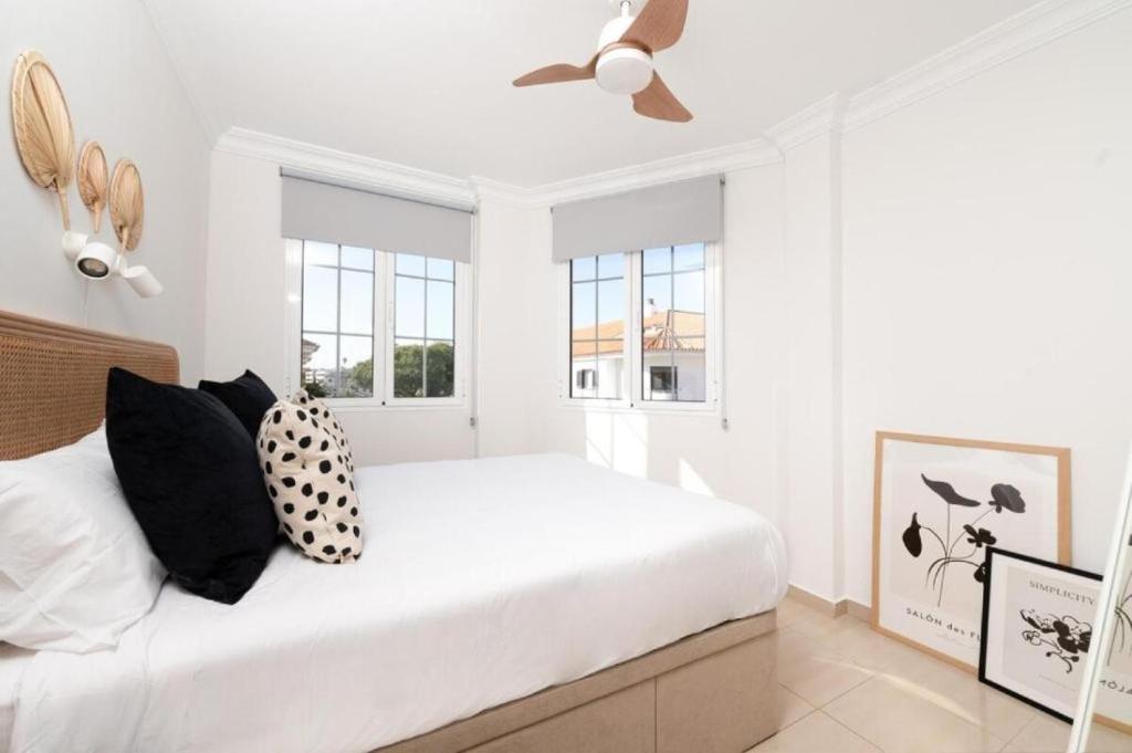 a white bedroom with a bed and windows at Casa Anik Boutique Home, La laguna in Las Lagunas