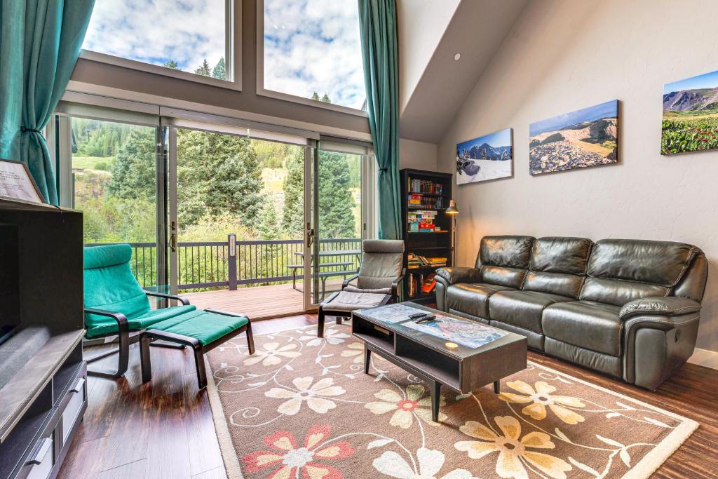 un soggiorno con divano in pelle e balcone di Ski-InandSki-Out Gemini Lift Access! Home with Hot Tub a Winter Park