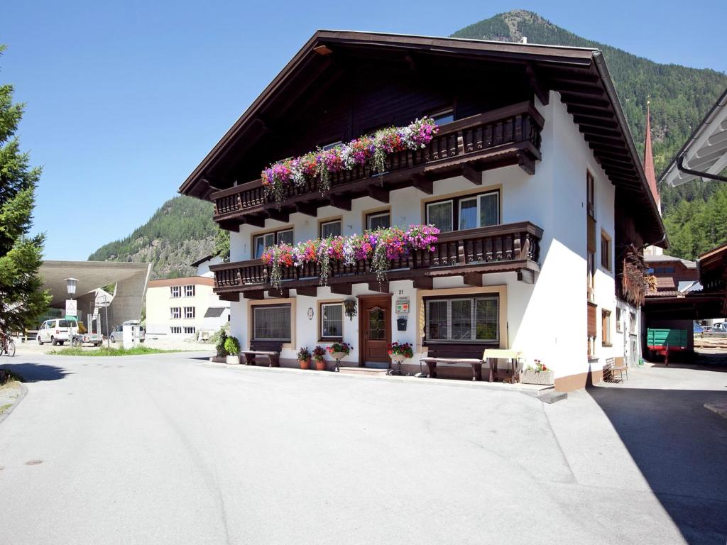 a building with flower boxes on the top of it at Apartment in Austria with Mountain Views in Längenfeld