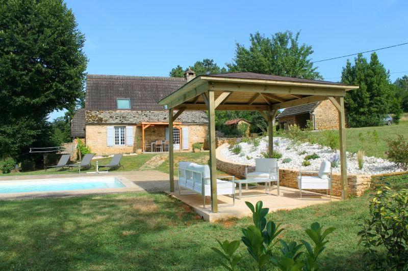 un gazebo con sedie e una piscina in un cortile di Les Mazaux avec piscine chauffée au nord de Sarlat a La Chapelle-Aubareil
