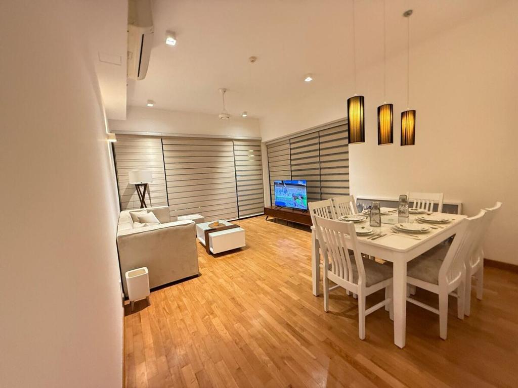 a dining room with a white table and a couch at Yara Colombo-a place to unwind in Colombo