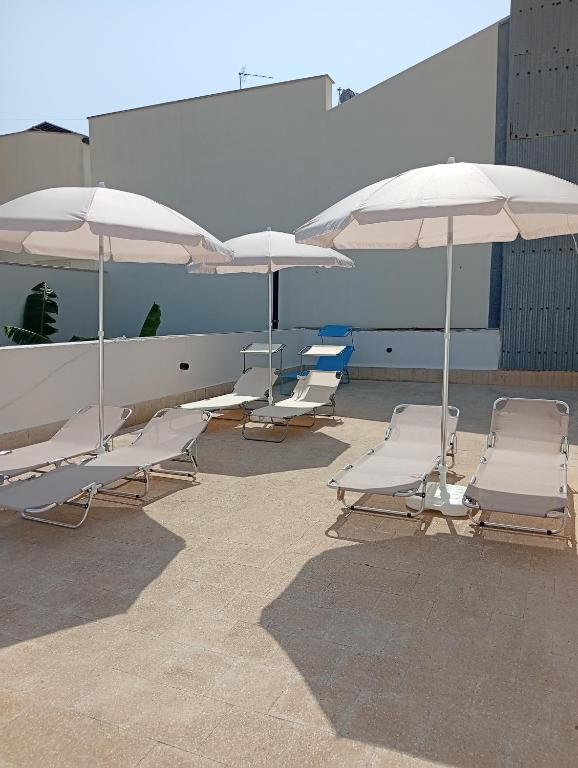 a group of chairs and umbrellas on a patio at U' Iazzu in Avola