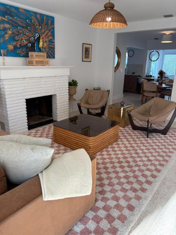 a living room with a couch and a fireplace at Mid-Century with Outdoor Oasis in Fort Lauderdale