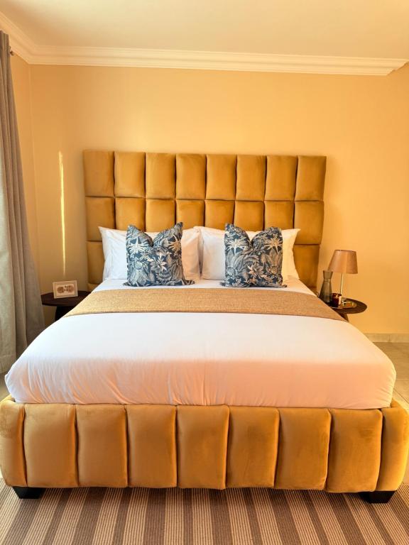 a large bed with a large headboard in a bedroom at Hamisi Manor Guest House in Midrand