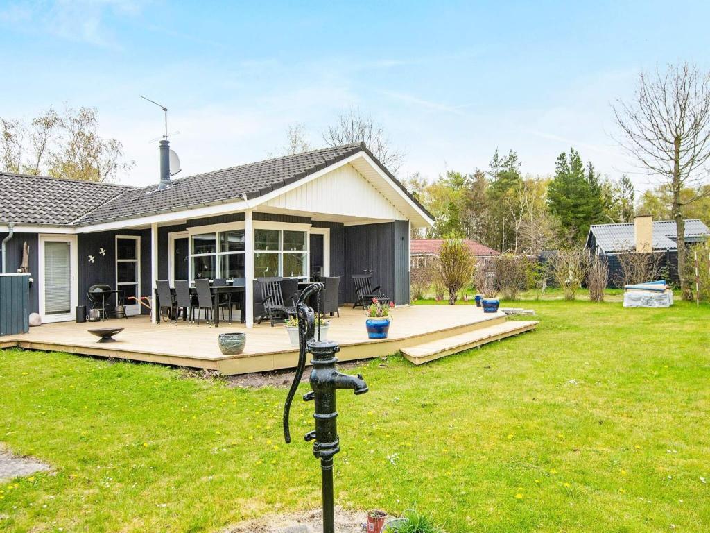 a house with a large backyard with a deck at Seaside Haven with Swing - By Traum Ferienwohnungen in Glesborg