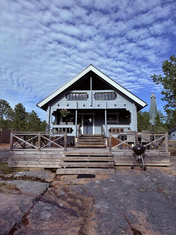 a large white house with a porch and an umbrella at Holmströms stugor in Eckerö