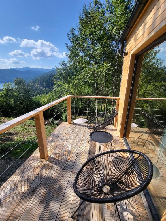 a deck with two chairs and a view of the mountains at Cabana Forest LakeView Potoci in Potoci