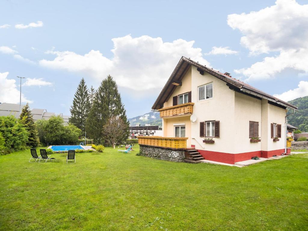 a house with a green yard with two chairs at Apartment in Tröpolach near Ski Lift in Tröpolach