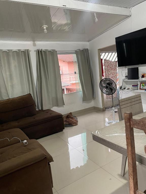 a living room with a couch and a flat screen tv at Casa para COP 30 in Ananindeua