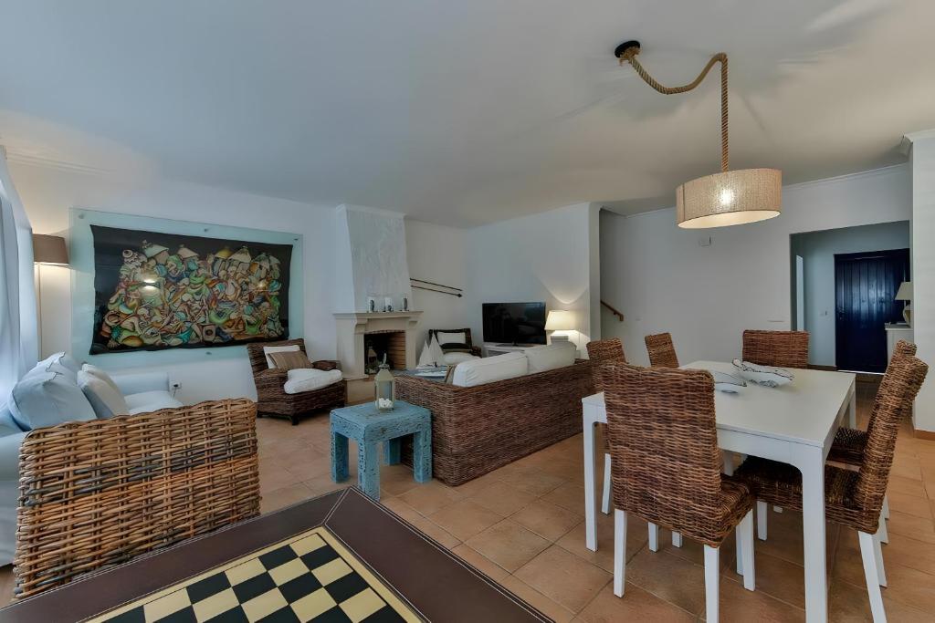 een woonkamer met een tafel, stoelen en een bank bij Praia Verde Beach House in Praia Verde