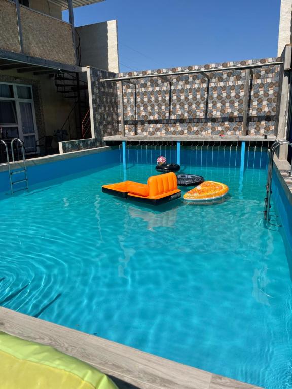a swimming pool with two inflatables in the water at Одесский дворик in Zatoka