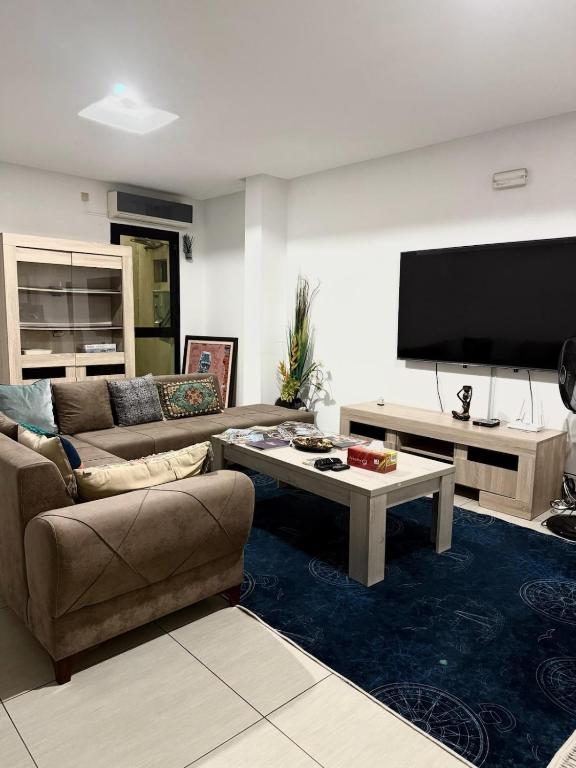 a living room with a couch and a tv at CHIC cozy appart bonoumin in Abidjan