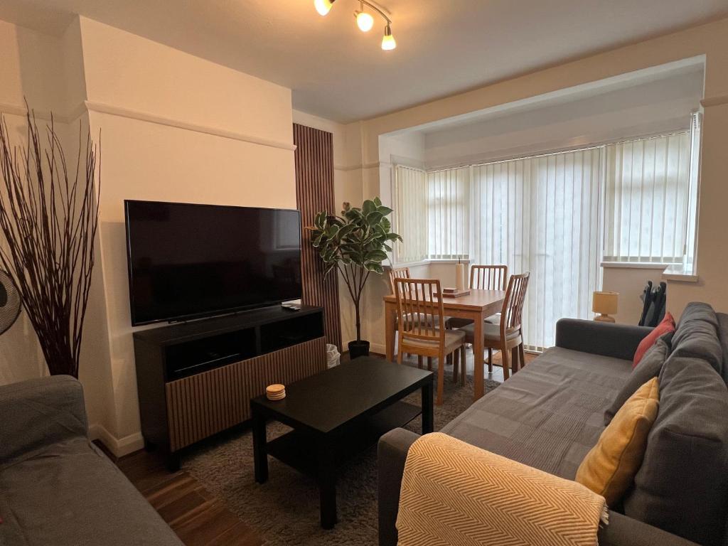 a living room with a couch and a table at 3 Bedroom modern house 15 min to tube, shops near by in Finchley