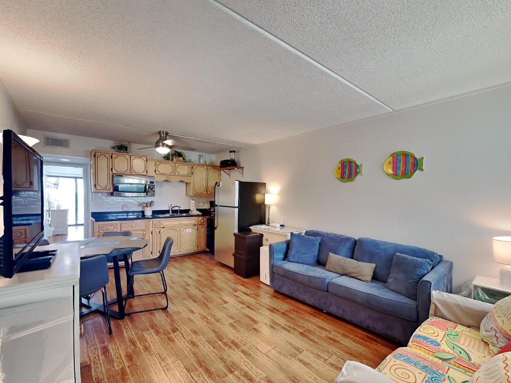 a living room with a blue couch and a kitchen at Villas Capri #9 in Fort Walton Beach