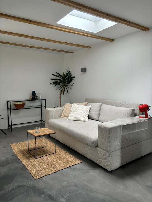 a living room with a couch and a table at Modernes Studio mit en-Suite Bad & bester Anbindung in Düsseldorf