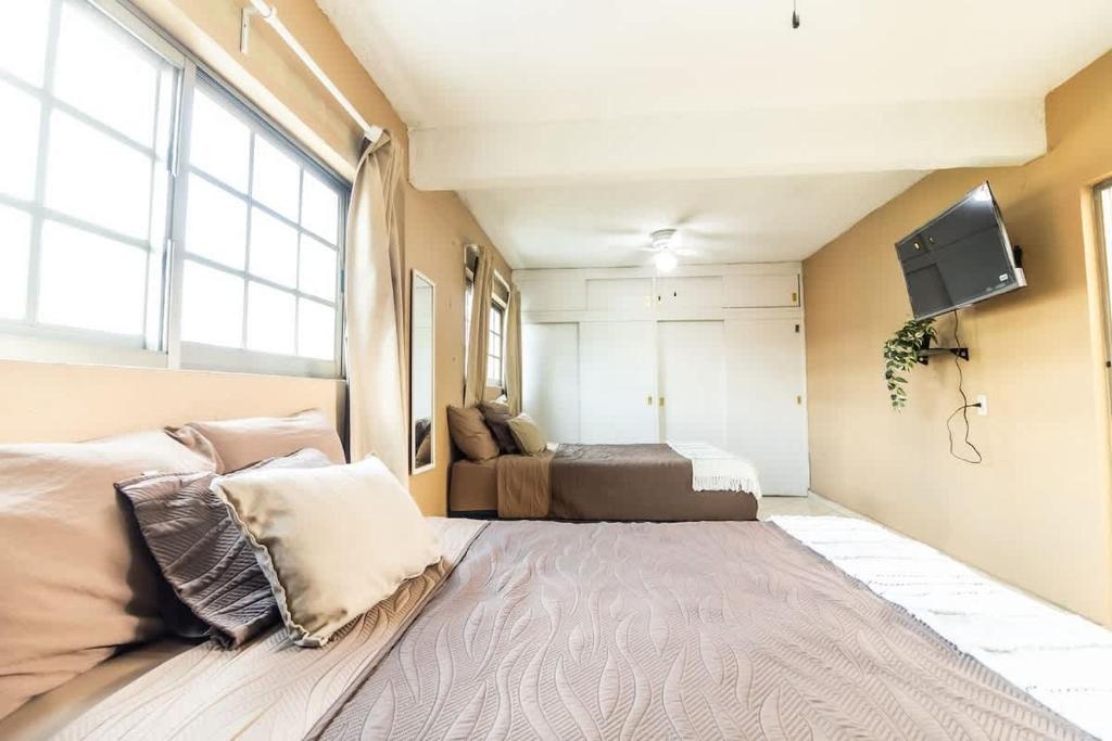 Un dormitorio con una cama y un televisor de pantalla plana. en Gaviota Family, en Guadalajara