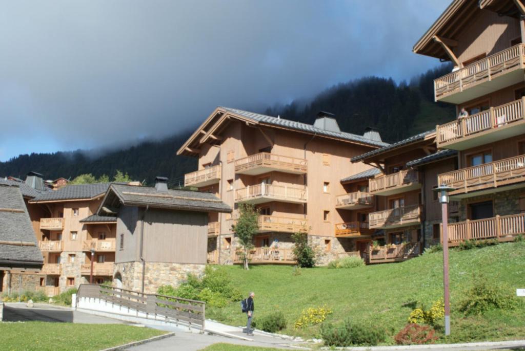 Villard-sur-DoronにあるLes Alpagesの大きなアパートの前を歩いている男性