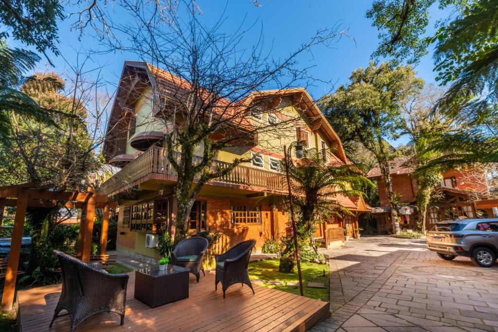 una casa con sillas en una terraza de madera en Pousada Monte Felice Recanto da Lua, en Gramado