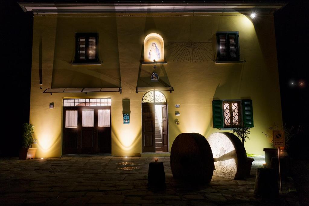 una casa illuminata di notte con una chiesa di Antica Macina Toscana a Pistoia