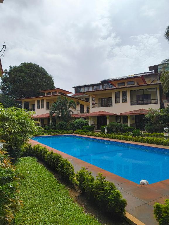 een zwembad voor een gebouw bij Navilehomestay in Candolim