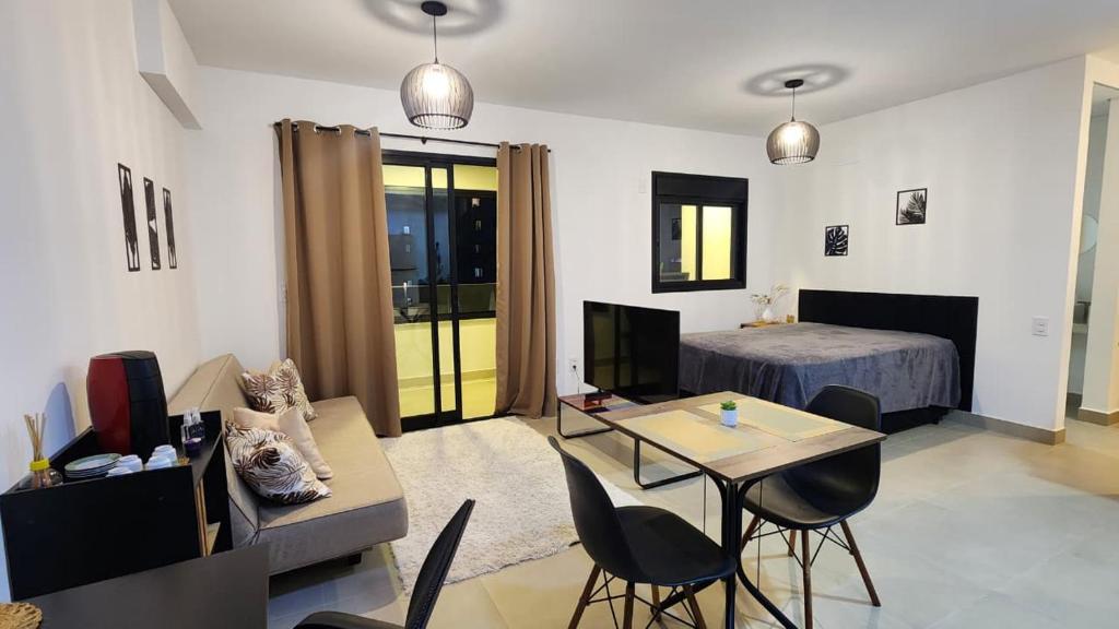 a living room with a room with a bed and a table at Studio em Sorocaba no Campolim in Sorocaba