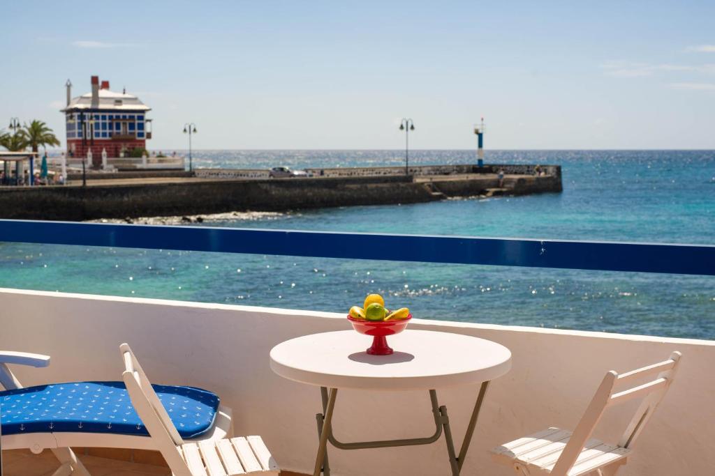 una mesa y sillas en un balcón con vistas al océano en Casa Varadero Arrieta, en Arrieta