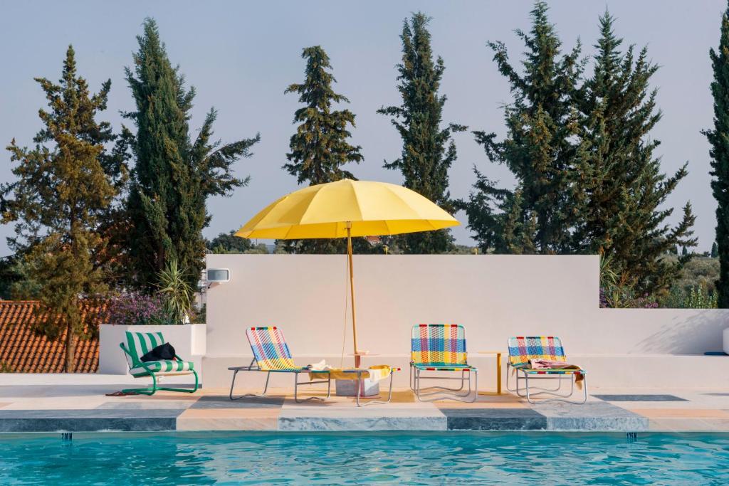 a group of chairs and an umbrella next to a pool at Calipo in Vila Viçosa