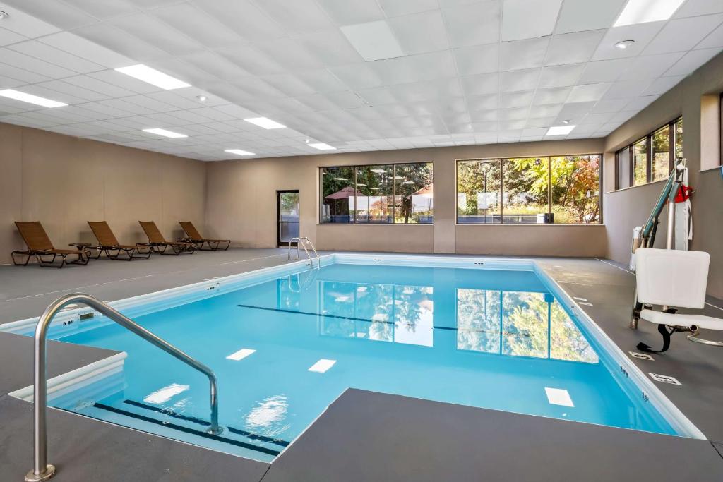 a swimming pool in a room with chairs and tables at Spark By Hilton Stevensville in Stevensville