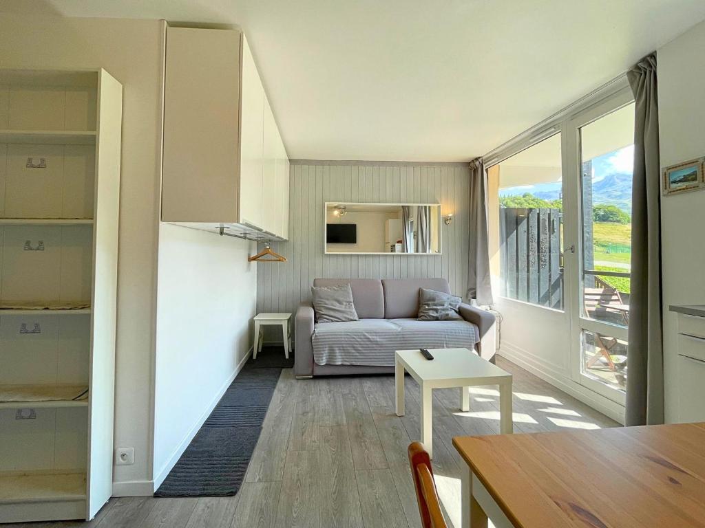 een woonkamer met een bank en een tafel bij Studio cabine rénové avec cuisine équipée aux Menuires - FR-1-452-2 in Les Menuires