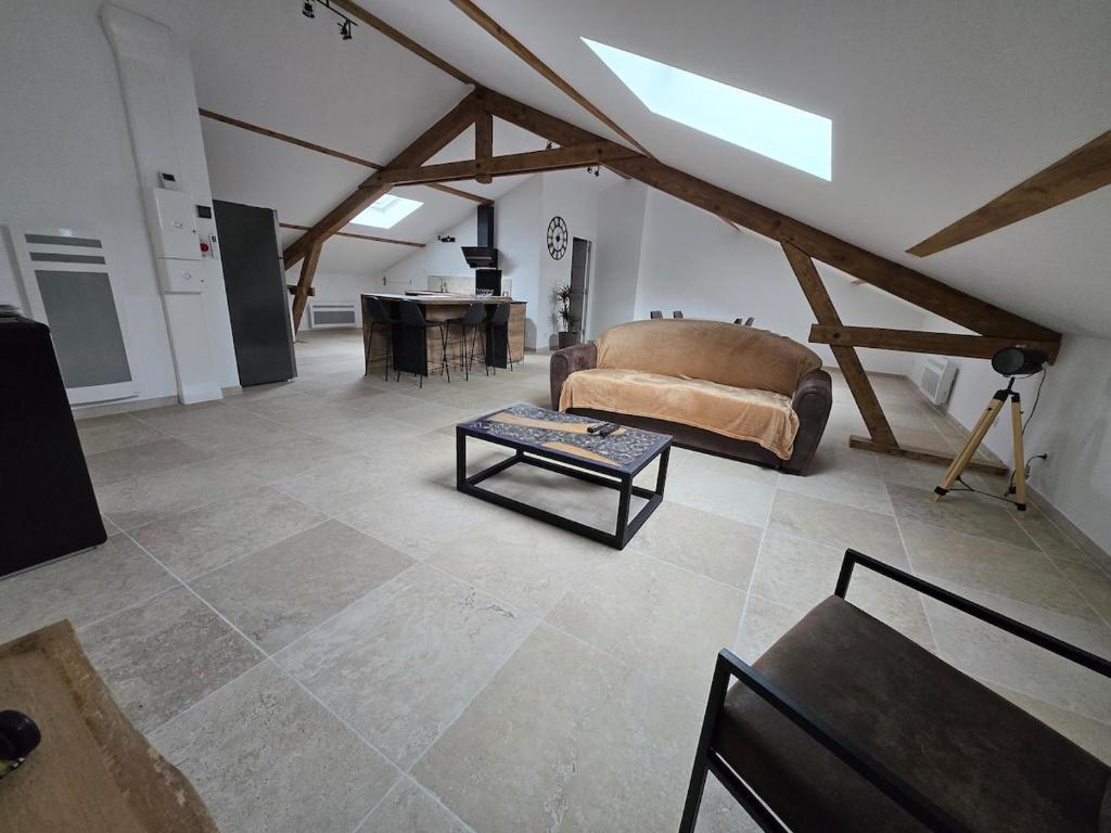 a living room with a couch and a table at Appartement centre de Toul avec jardin in Toul